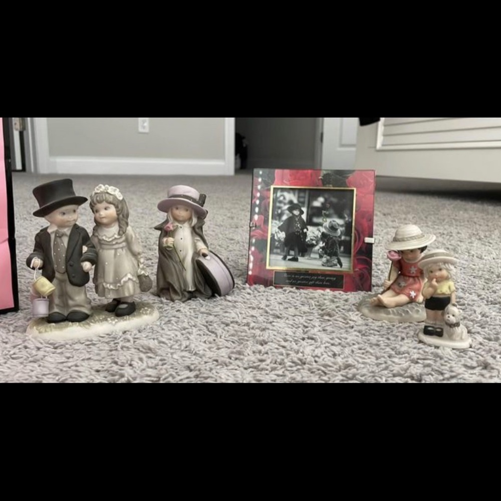 4 black and white collectible figurines and one framed black-and-white photo